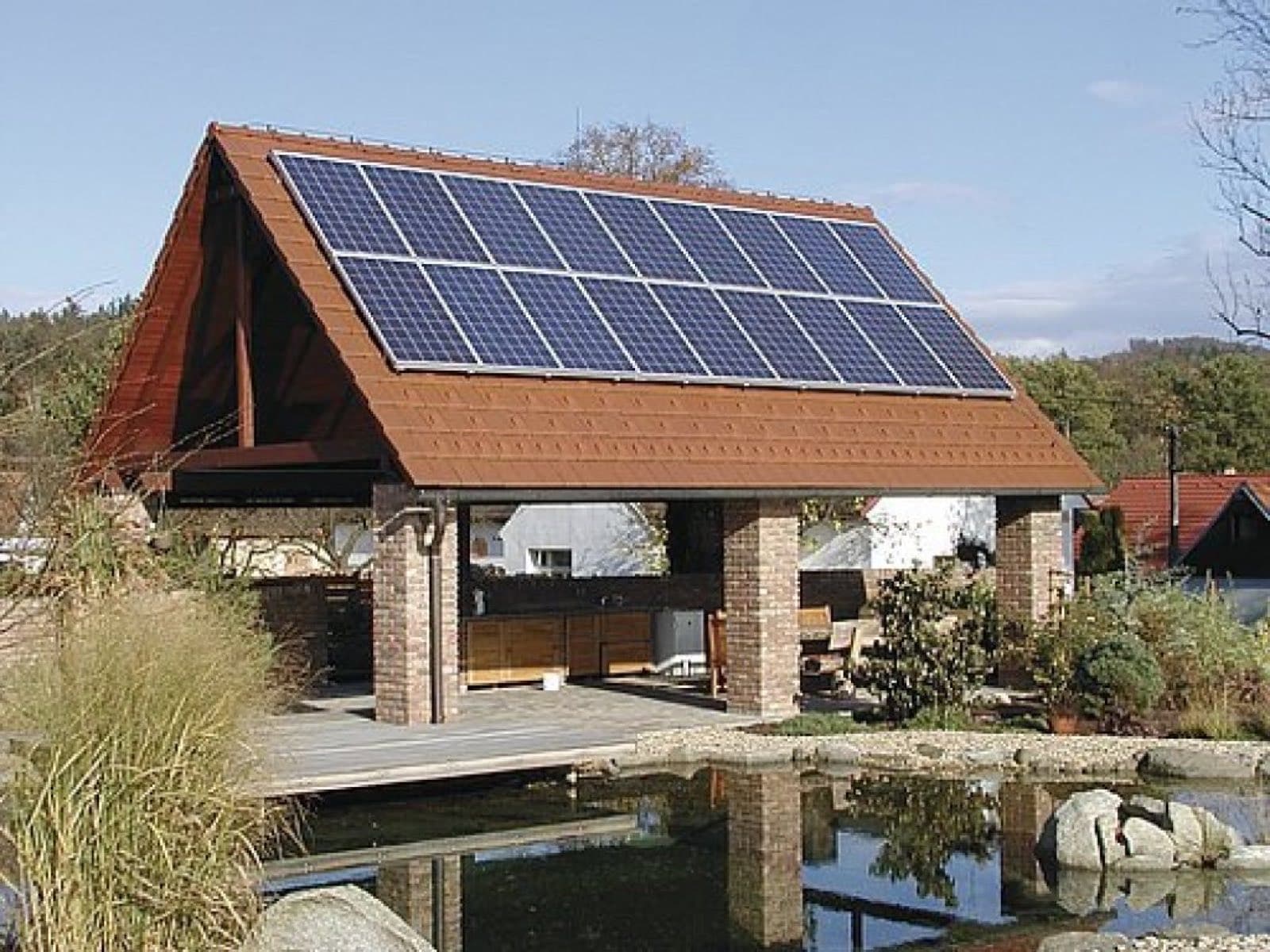Fotovoltaické panely na střeše zahradní pergoly u domu