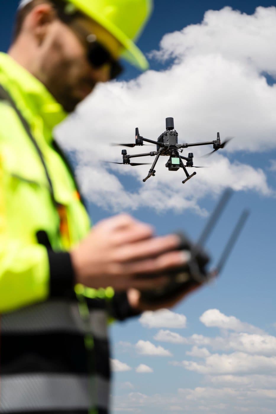 Pilot s ovladačem a inspekčním dronem ve vzduchu